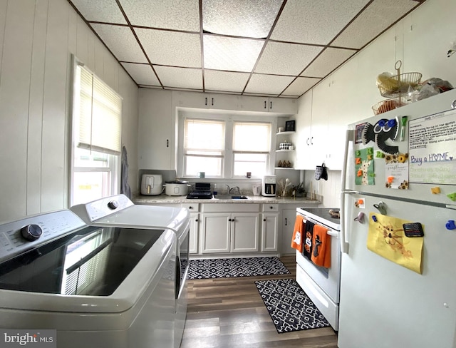 kitchen featuring sink, dark hardwood / wood-style floors, independent washer and dryer, white appliances, and white cabinets