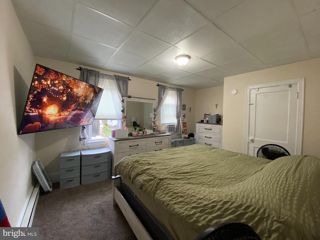 carpeted bedroom featuring a paneled ceiling and baseboard heating