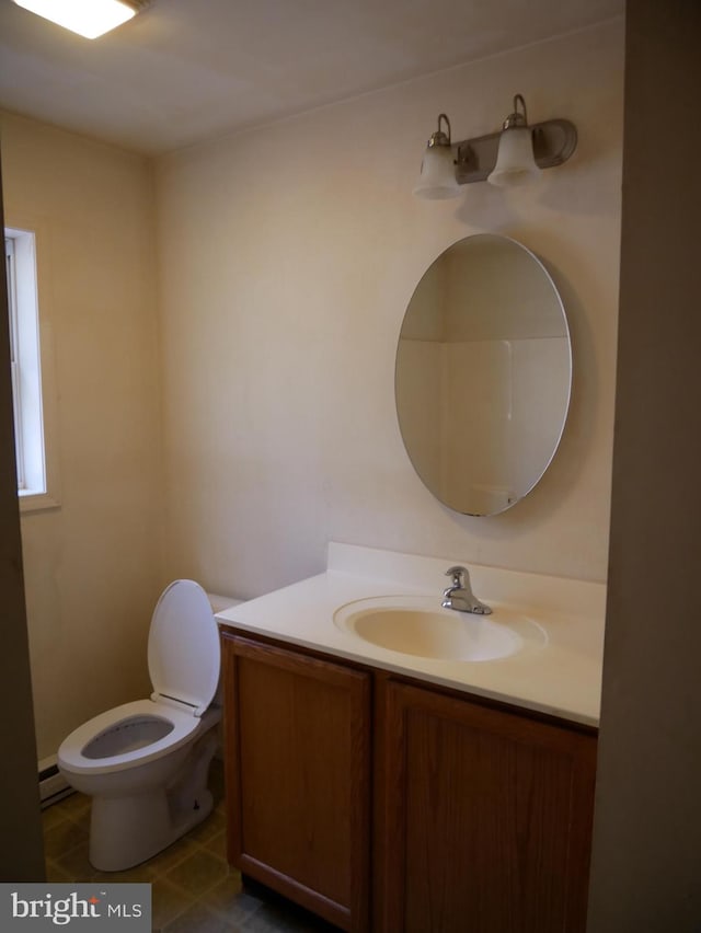 bathroom with toilet, baseboard heating, vanity, and tile patterned flooring