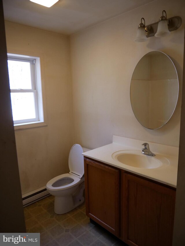 bathroom with toilet, baseboard heating, and vanity