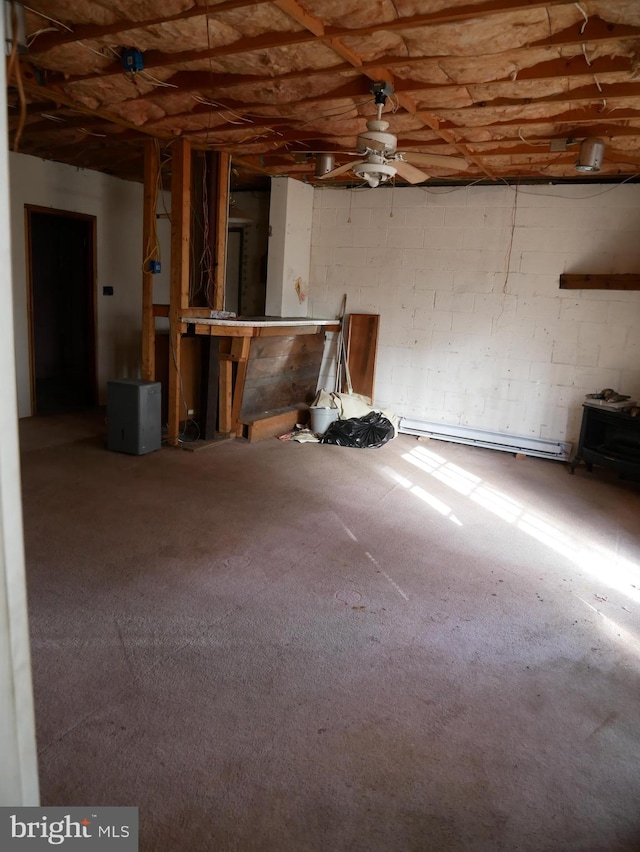 basement featuring ceiling fan and a baseboard radiator