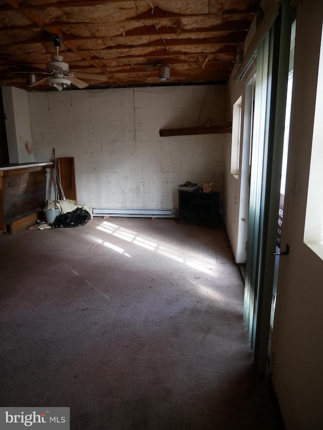 basement with a baseboard heating unit and ceiling fan