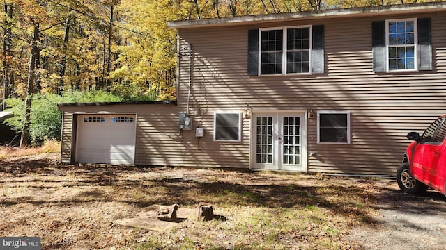 rear view of property featuring an outdoor structure and a garage