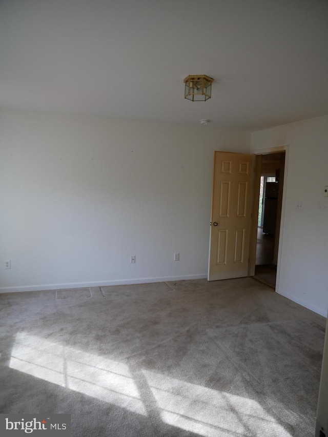 spare room featuring light colored carpet