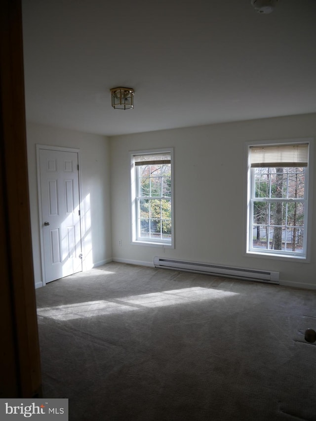 carpeted spare room with a baseboard radiator