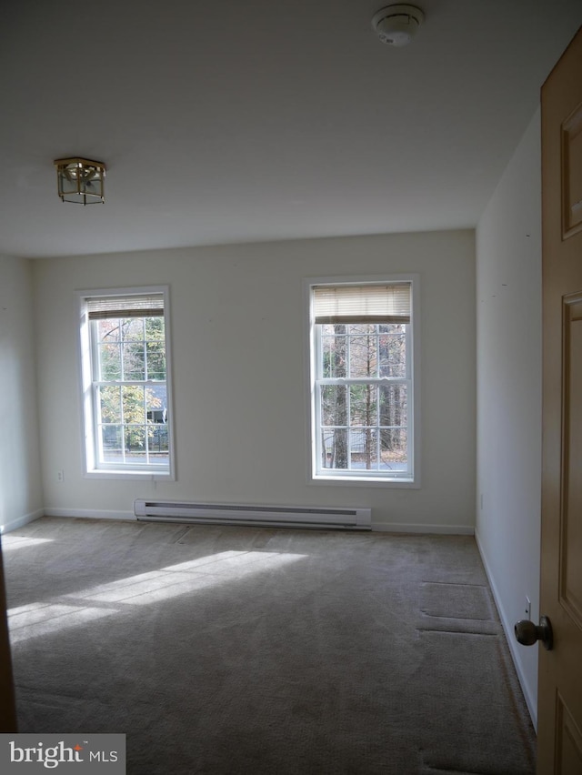 empty room featuring baseboard heating, light carpet, and a healthy amount of sunlight