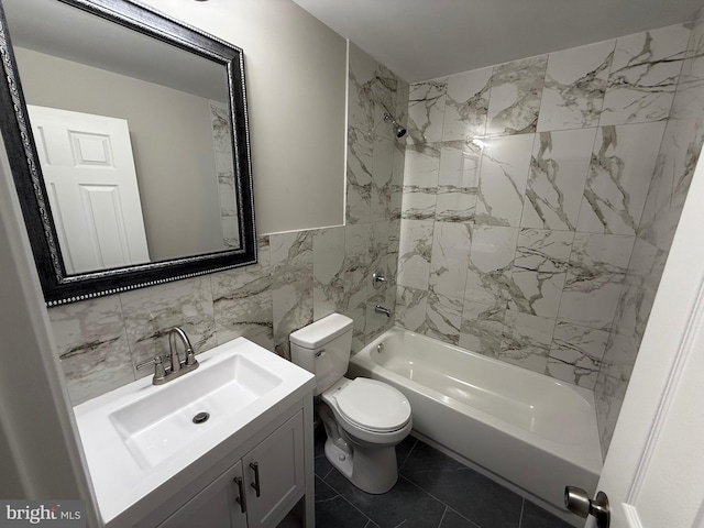 full bathroom with tile walls, tile patterned floors, vanity, tiled shower / bath combo, and toilet