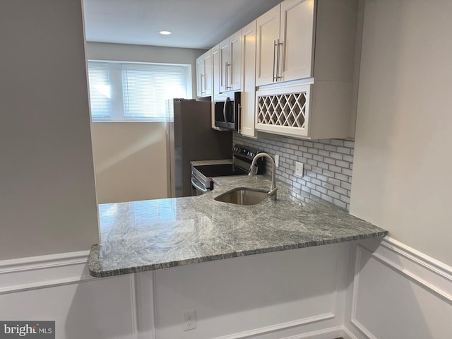 kitchen featuring white cabinetry, appliances with stainless steel finishes, backsplash, and stone counters