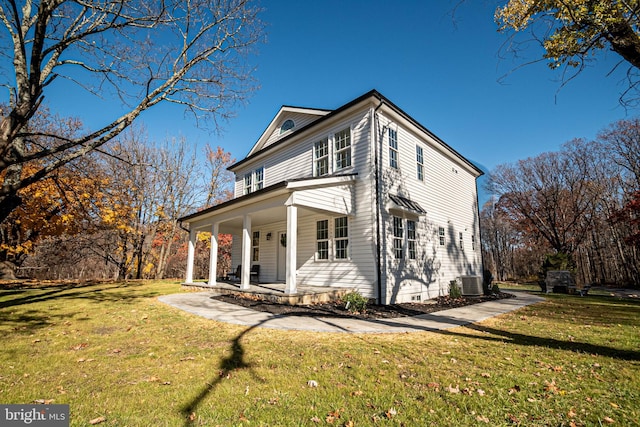 view of side of property with a porch, cooling unit, and a lawn