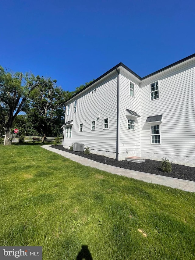 view of home's exterior featuring central air condition unit and a lawn