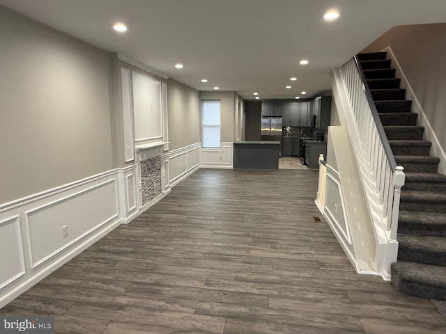 interior space featuring dark hardwood / wood-style floors, stainless steel fridge, and black range with electric stovetop