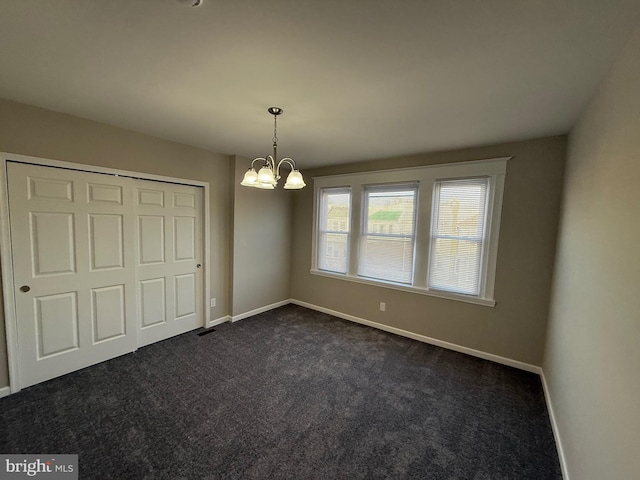 interior space with dark carpet and an inviting chandelier