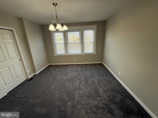 carpeted spare room with a notable chandelier