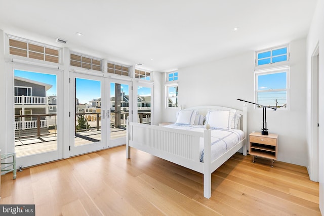 bedroom featuring visible vents, light wood finished floors, access to outside, and multiple windows