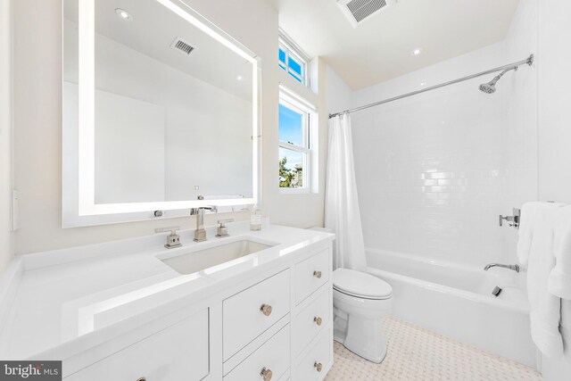 bathroom featuring shower / bath combo with shower curtain, visible vents, toilet, and vanity