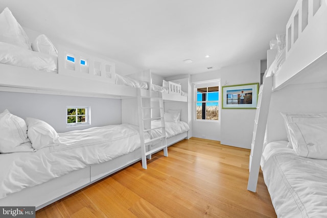 bedroom with recessed lighting, multiple windows, and wood finished floors