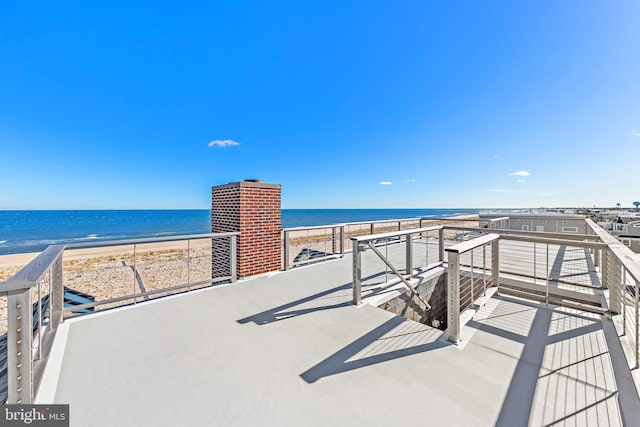 view of patio / terrace featuring a water view and a view of the beach