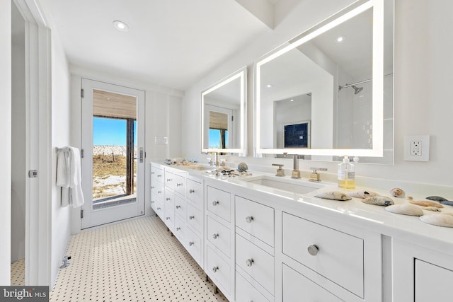 full bath featuring tile patterned floors, double vanity, and a sink
