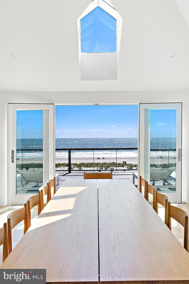 unfurnished dining area featuring a water view and a beach view