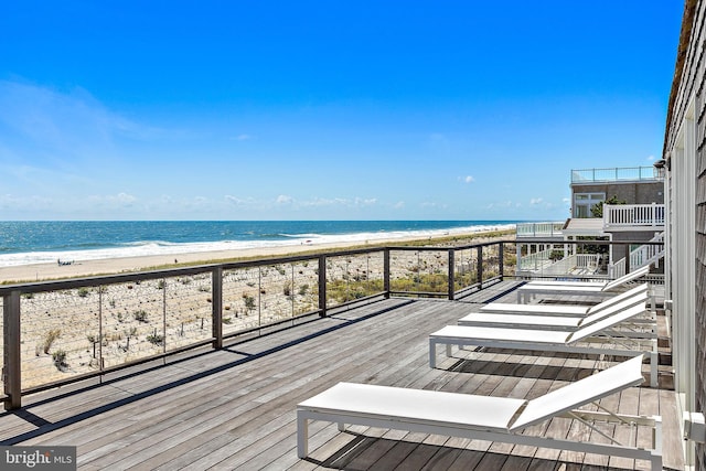 deck featuring a view of the beach and a water view