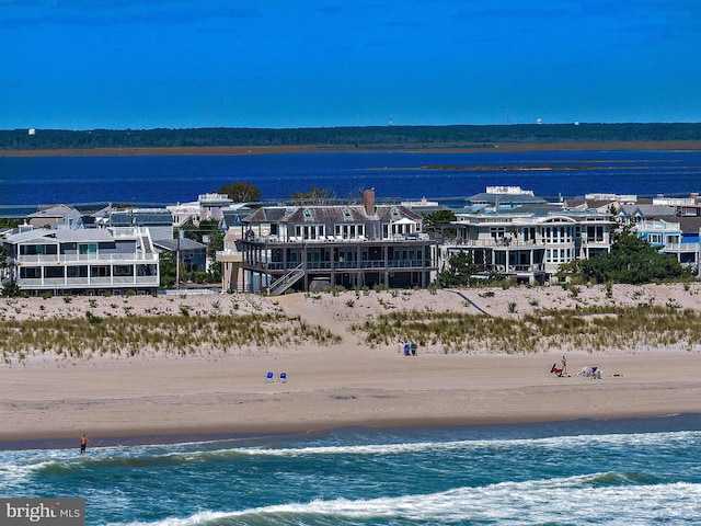 bird's eye view featuring a water view and a beach view