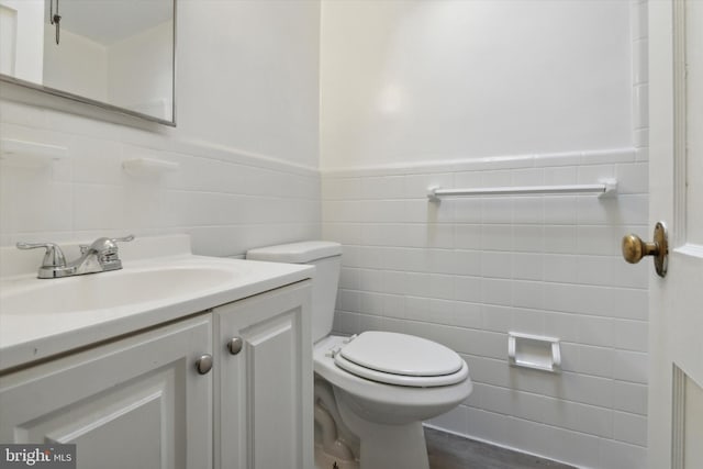 bathroom with tile walls, vanity, hardwood / wood-style flooring, and toilet