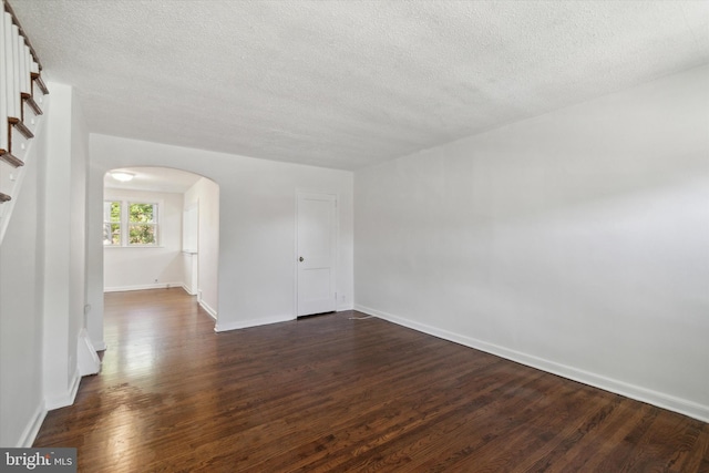 unfurnished room with a textured ceiling and dark hardwood / wood-style flooring