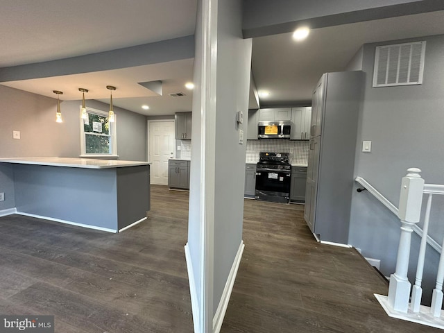 kitchen with black gas range, gray cabinets, dark hardwood / wood-style flooring, and kitchen peninsula