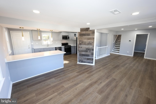 kitchen featuring sink, dark wood-type flooring, stainless steel appliances, decorative light fixtures, and gray cabinets