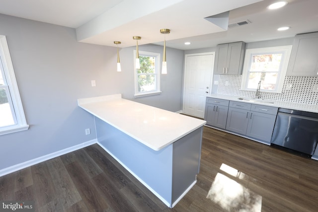 kitchen featuring dishwasher, dark hardwood / wood-style flooring, kitchen peninsula, and sink