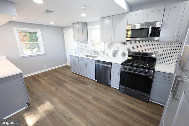 kitchen featuring a healthy amount of sunlight, sink, stainless steel appliances, and dark hardwood / wood-style floors