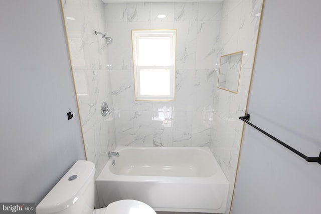 bathroom featuring toilet and tiled shower / bath