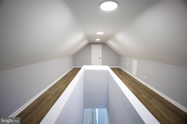 hallway featuring dark hardwood / wood-style flooring and lofted ceiling