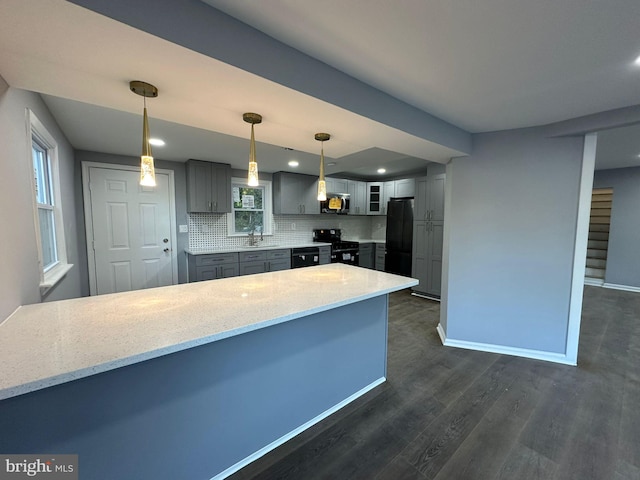 kitchen with sink, hanging light fixtures, dark wood-type flooring, tasteful backsplash, and black appliances