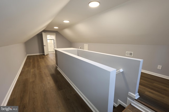 corridor featuring vaulted ceiling and dark wood-type flooring