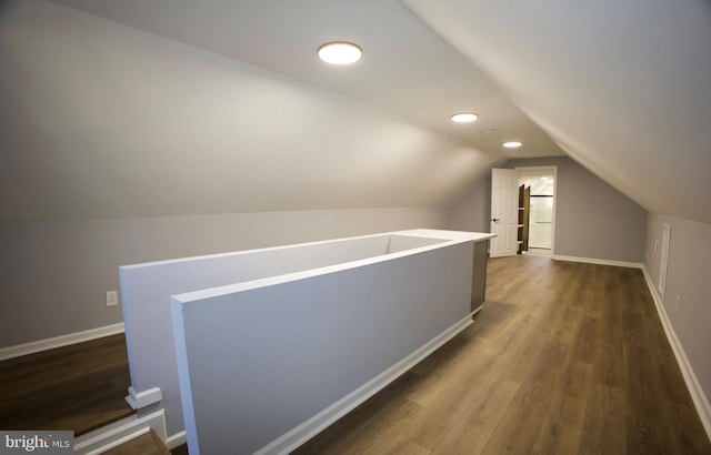 hall with dark hardwood / wood-style flooring and vaulted ceiling