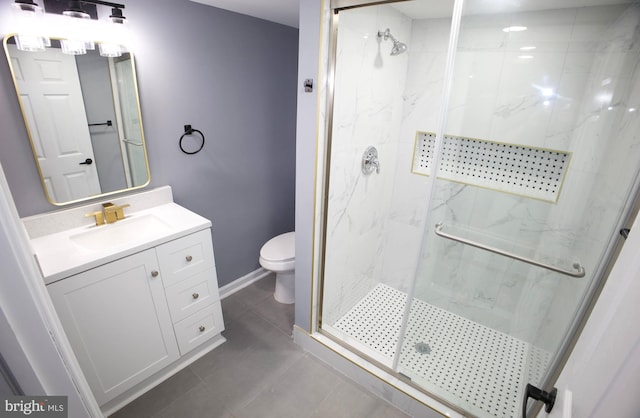 bathroom featuring tile patterned flooring, vanity, toilet, and a shower with shower door