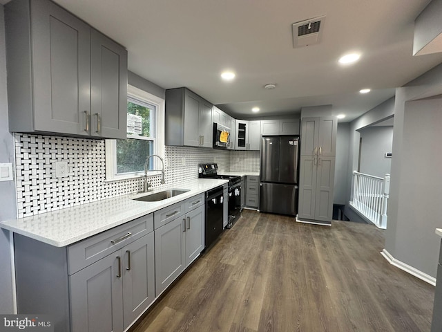 kitchen featuring gray cabinetry, sink, dark wood-type flooring, and black appliances