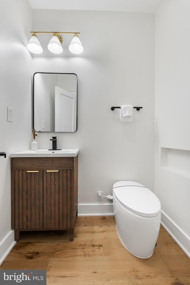 bathroom with vanity, toilet, and wood-type flooring