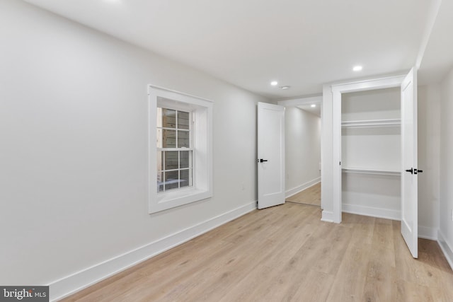 unfurnished bedroom with a closet and light hardwood / wood-style floors