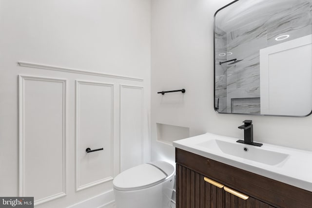 bathroom with vanity, toilet, and a tile shower