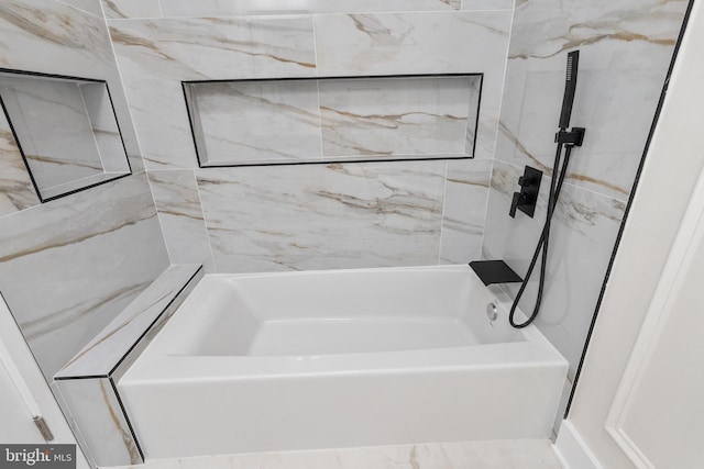 bathroom featuring tiled shower / bath