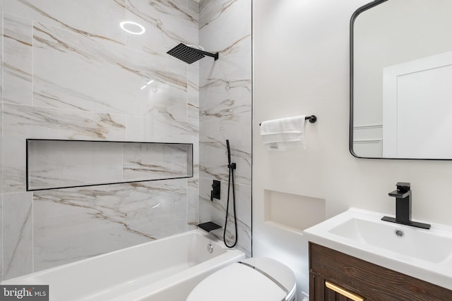 full bathroom featuring tiled shower / bath, vanity, and toilet