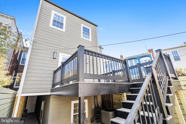 back of property featuring central AC and a deck