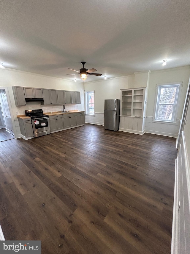 kitchen featuring appliances with stainless steel finishes, gray cabinets, a healthy amount of sunlight, and dark wood-style floors