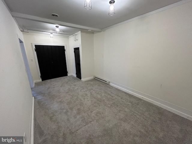 spare room featuring carpet floors, a baseboard heating unit, visible vents, and baseboards