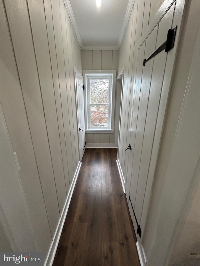 corridor with dark wood-style floors, baseboards, and crown molding