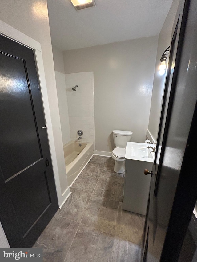 bathroom featuring toilet, shower / bathtub combination, vanity, and baseboards