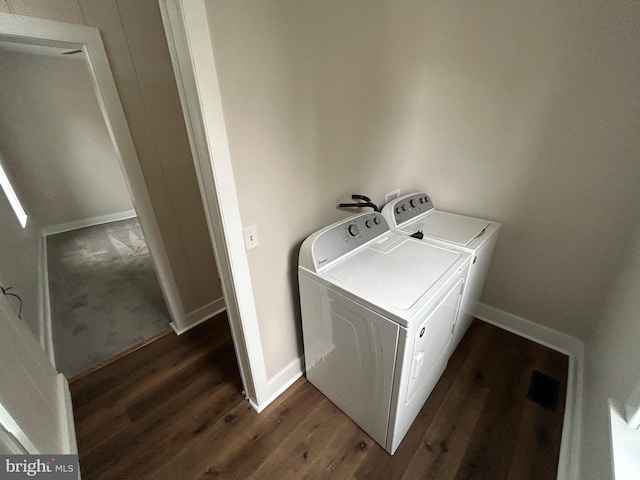 laundry room featuring laundry area, dark wood-style flooring, washing machine and dryer, and baseboards