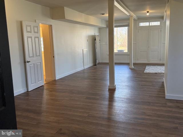 foyer entrance with dark wood-style floors and baseboards